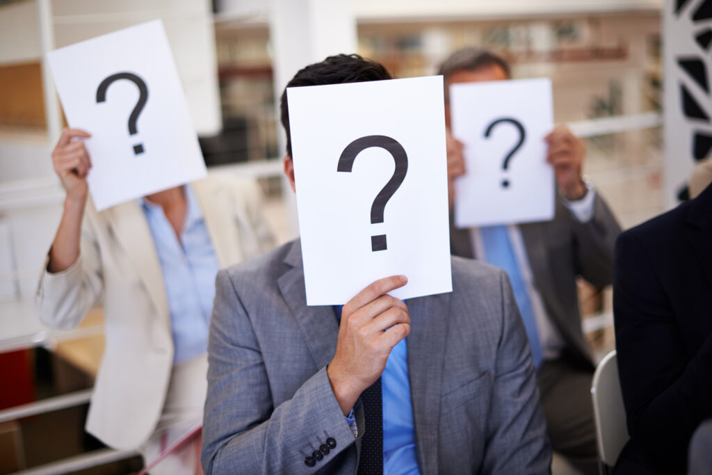 Marketing campaign managers holding papers with question marks